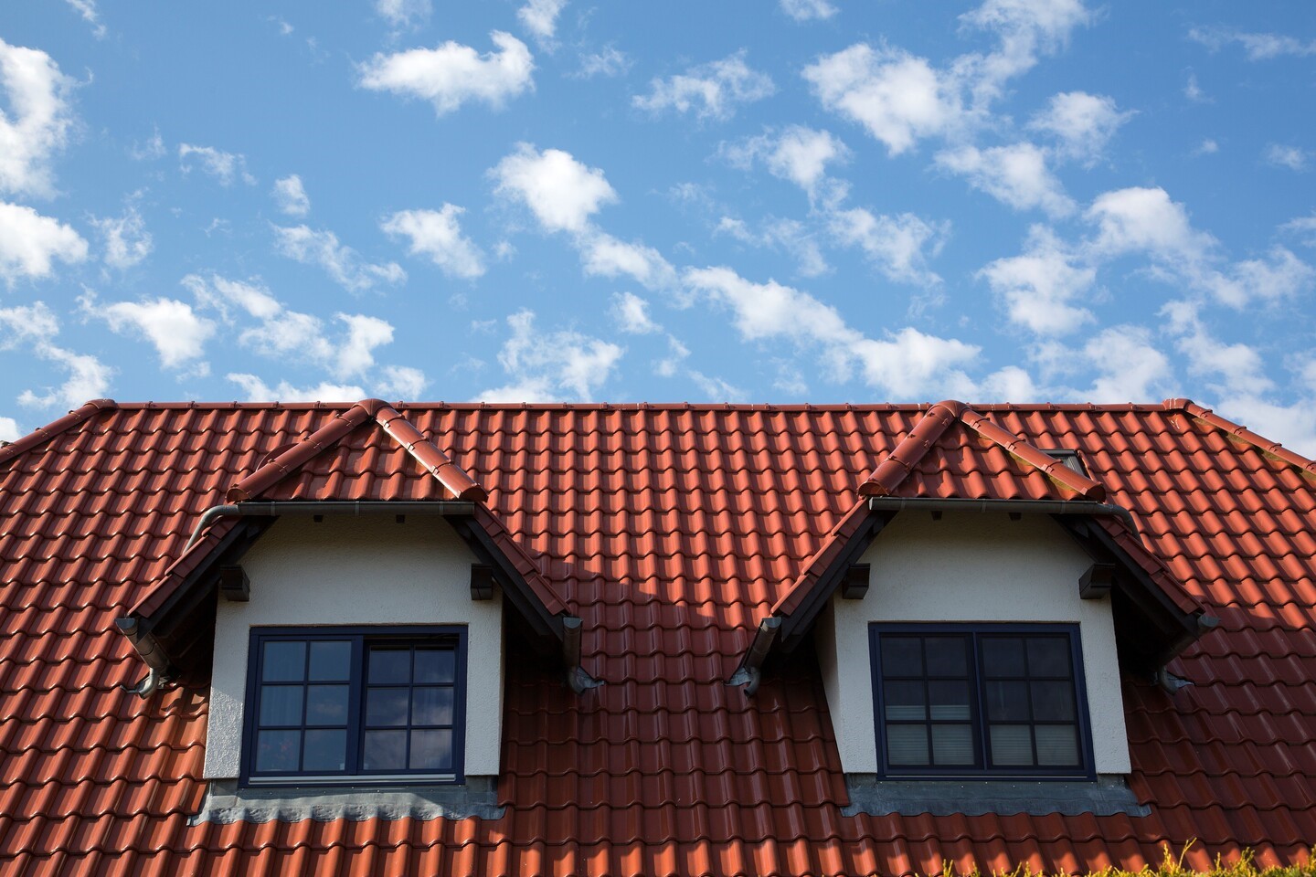 dach pokryty ceramiczną, czerwoną dachówką, z przodu dwa, symetrycznie ustawione okna