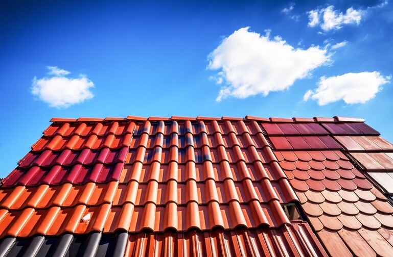 wiele rodzajów dachówek ceramicznych i cementowych, w różnych kolorach ułożonych na jednej konstrukcji dachu