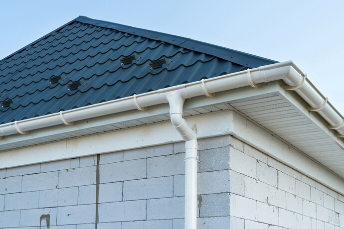 nowy dach, pokryty grafitową blachodachówką z białą, plastikową rynną