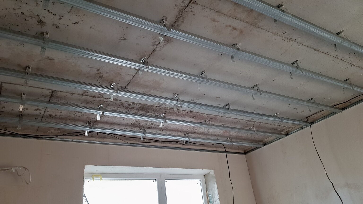 symetryczny rozstaw profili aluminiowych na suficie podwieszanym w nowo wybudowanym budynku