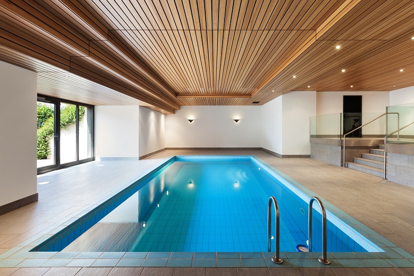 Drewniany sufit podwieszany w dużym, przestronnym pomieszczeniu z basenem
